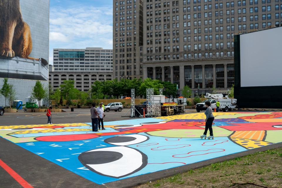 People paint murals for the soon to be opening Monroe Street Midway in downtown Detroit on May 24, 2021.