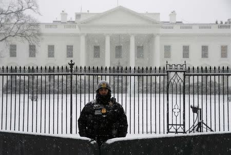 A uniformed Secret Service officer stands in the freshly fallen snow outside the White House in Washington January 22, 2016. REUTERS/Jonathan Ernst