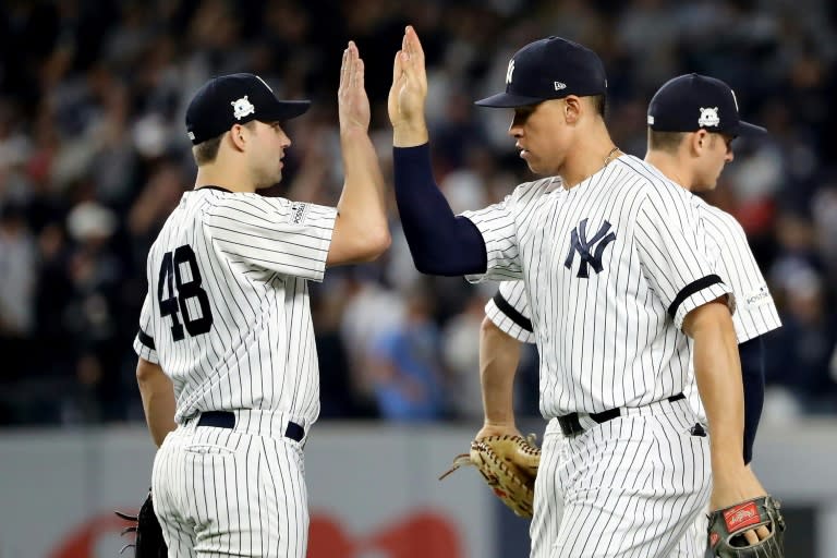 Tommy Kahnle (L) and Aaron Judge of the New York Yankees celebrate after defeating the Houston Astros in Game Five of the American League Championship Series, at Yankee Stadium in New York, on October 18, 2017