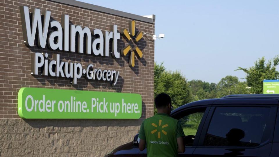 A Wal-Mart Pickup-Grocery employee helps a customer at a test store in Bentonville.