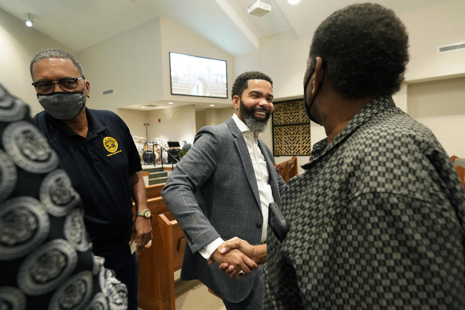 Jackson, Miss., Mayor Chokwe Antar Lumumba, center, greets a resident following a community meeting at College Hill Missionary Baptist Church, Tuesday, Sept. 13, 2022. The meeting was held to update the public on the current water system situation. (AP Photo/Rogelio V. Solis)