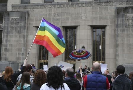 Supporters of same-sex marriage hold a rainbow flag and a rainbow umbrella outside Jefferson County Courthouse in Birmingham, Alabama February 9, 2015. REUTERS/Marvin Gentry