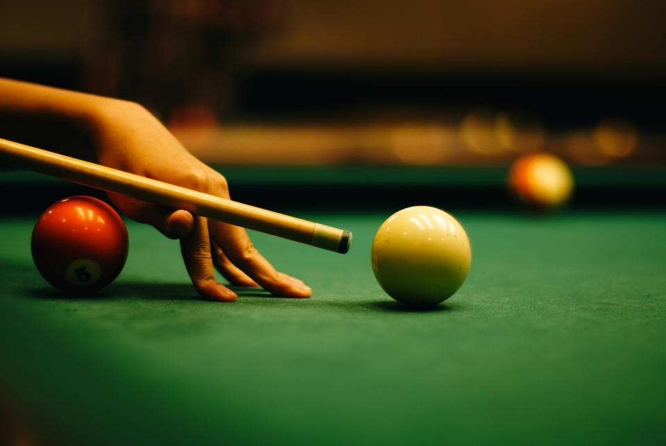 woman's hand setting up a shot on a pool table