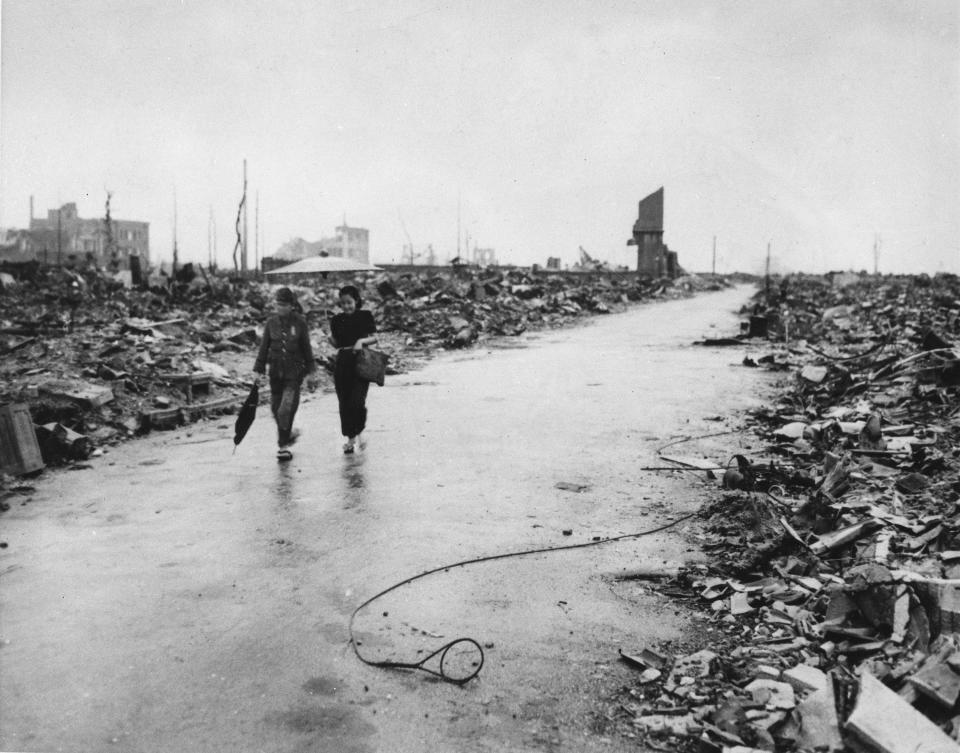 Two people walk on a cleared path through the destruction resulting from the Aug. 6 detonation of the first atomic bomb, Sept. 8, 1945.