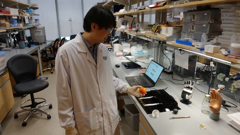 Dr. Benjamin Tee prepares to demonstrate how his device can detect the texture of a soft stress ball at a NUS lab in Singapore