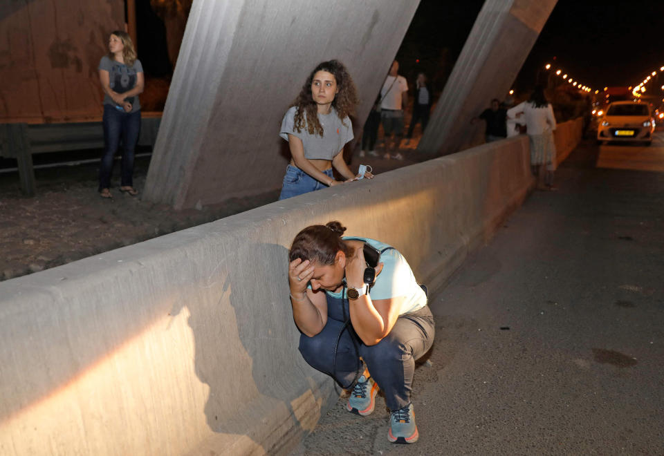 Image: People take cover under a bridge at the entrance of Israel's central city of Tel Aviv, (Gil Cohen-Magen / AFP - Getty Images)