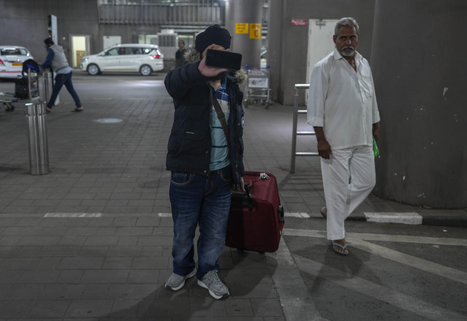 An Indian passenger who travelled in an unmarked Legend Airlines A340 from Vatry Airport in France, hides his face as he arrives at the Chhatrapati Shivaji Maharaj International Airport in Mumbai, India, Tuesday, Dec. 26, 2023. A charter plane that was grounded in France for a human trafficking investigation arrived in India with 276 Indians aboard early Tuesday, authorities said. The passengers had been heading to Nicaragua but were instead blocked inside the Vatry Airport for four days in an exceptional holiday ordeal. (AP Photo/Rafiq Maqbool)