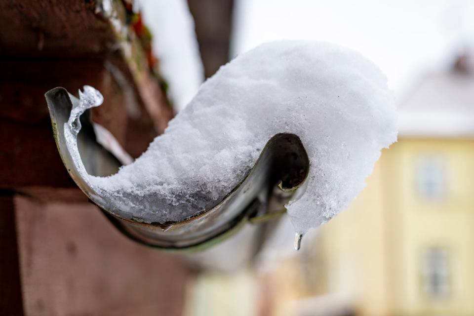 A close up of snow and ice filling a gutter. 