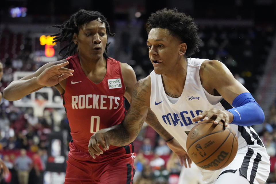 Orlando Magic's Paolo Banchero drives around Houston Rockets' TyTy Washington Jr. during the first half an NBA summer league basketball game Thursday, July 7, 2022, in Las Vegas. (AP Photo/John Locher)