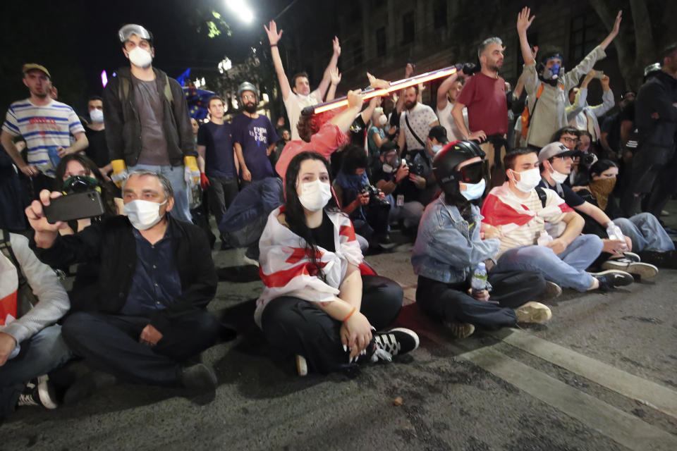 Demonstrators sit in front of police line during an opposition protest against "the Russian law" near the Parliament building in Tbilisi, Georgia, on Tuesday, April 30, 2024. Clashes erupted between police and opposition demonstrators protesting a new bill intended to track foreign influence that the opposition denounced as Russia-inspired. (AP Photo/Zurab Tsertsvadze)