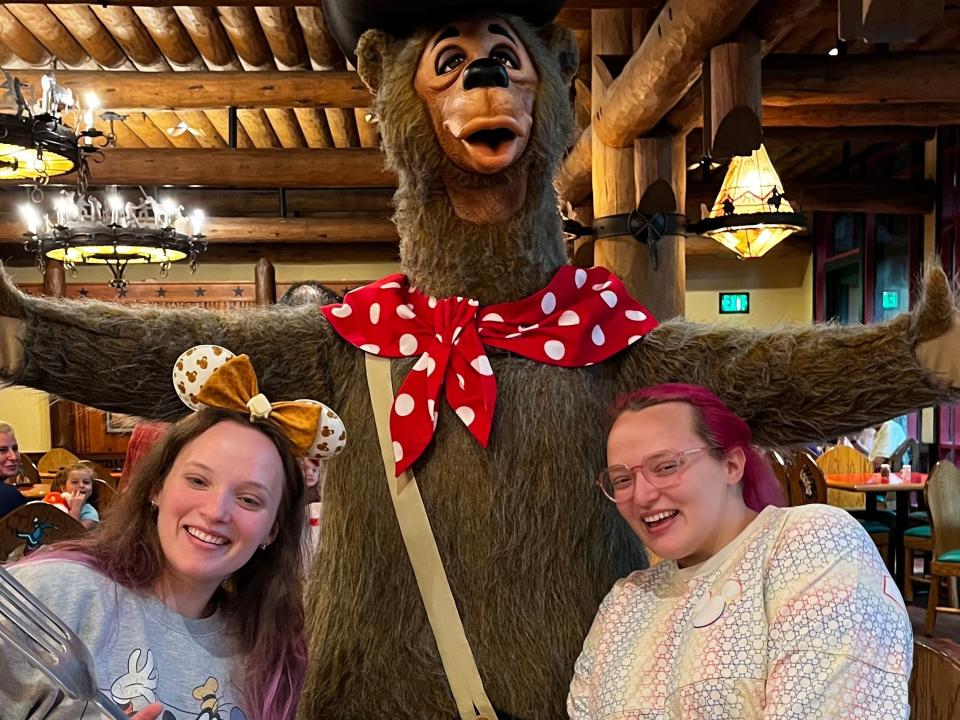 writer and friend with a disney character at a resort