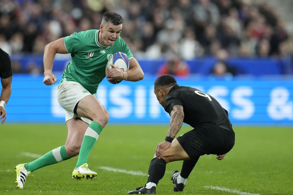 Ireland's Johnny Sexton, left, runs towards New Zealand's Aaron Smith during the Rugby World Cup quarterfinal match between Ireland and New Zealand at the Stade de France in Saint-Denis, near Paris Saturday, Oct. 14, 2023. (AP Photo/Christophe Ena)