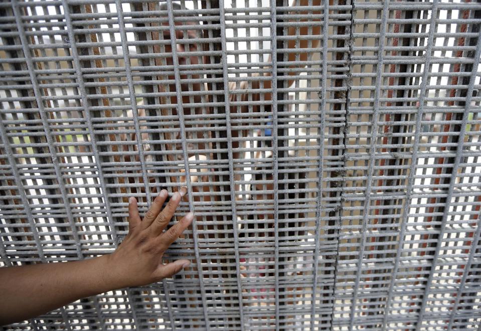 In this July 14, 2013 photo, the hand of Marta Lopez, left, touches the finger of her daughter Alondra Lopez, 8, as they stand separated by a fence between Tijuana, Mexico, and San Diego during a Sunday mass celebration. San Diego is a border city but it often does not feel like one despite the fact its center is less than a 20-minute drive to Mexico. The best way to see the border without crossing it is at Border Field State Park, which is at the farthest southwest corner of the United States. (AP Photo/Gregory Bull)