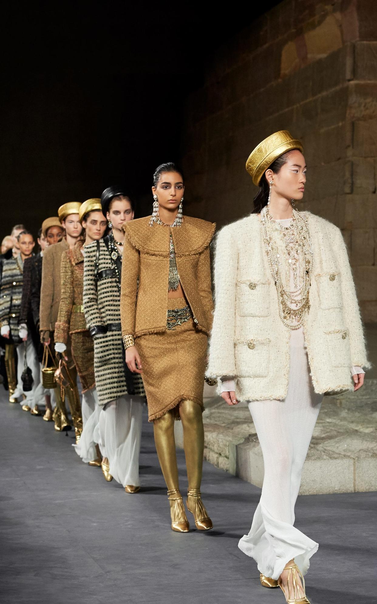 Models with legs painted gold wear embellished tweed and carry scarab-shaped iridescent bags - Chanel