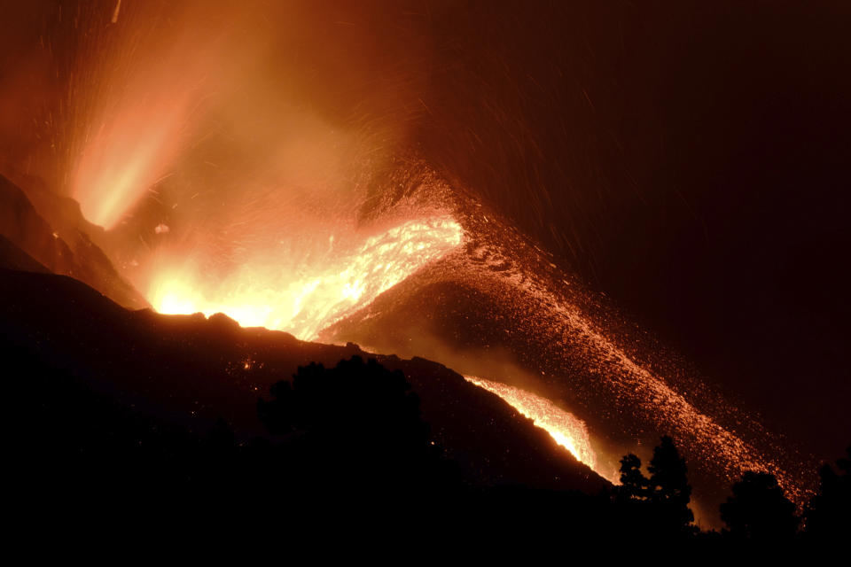 A volcano continues to spew out lava on the Canary island of La Palma, Spain in the early hours of Sunday, Oct. 10, 2021. A new river of lava has belched out from the La Palma volcano, spreading more destruction on the Atlantic Ocean island where molten rock streams have already engulfed over 1,000 buildings. The partial collapse of the volcanic cone has sent a new lava stream heading toward the western shore of the island. (AP Photo/Daniel Roca)