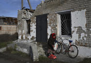 An elderly woman receives a food at a mobile humanitarian aid point in the village of Zarichne, Donetsk region, Ukraine, Friday, Dec. 2, 2022. (AP Photo/Andriy Andriyenko)