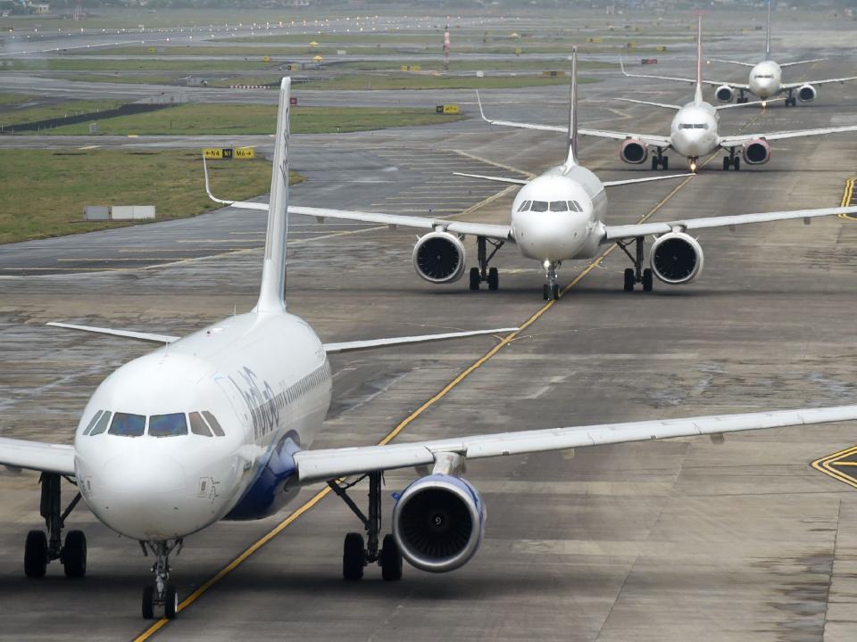 Flugzeuge warten in einer Schlange auf einer Startbahn auf den Start. - Copyright: PUNIT PARANJPE/AFP via Getty Images