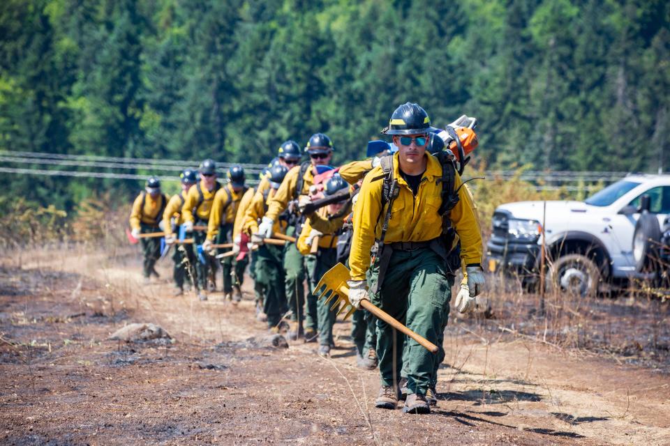 Firefighters march toward the blaze on Moon Mountain while working the fire in Eugene Tuesday, July 4, 2023. 