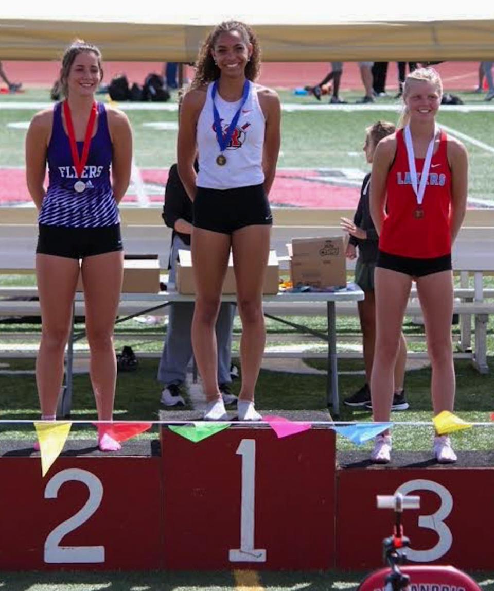 Cecelia Woods smiles from the podium of a meet during the 2023 track season.
