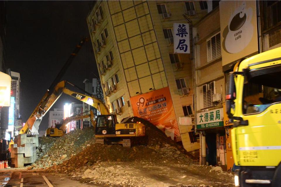 「富凱大飯店」正進行拆除準備，載運土石防止大樓傾斜。（王志偉攝）