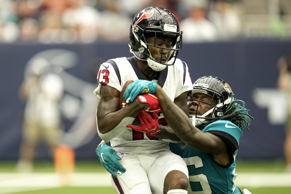 Houston Texans wide receiver Brandin Cooks (13) catches a pass for a first down as Jacksonville Jaguars cornerback Shaquill Griffin (26) defends during the first half of an NFL football game Sunday, Sept. 12, 2021, in Houston. (AP Photo/Sam Craft)