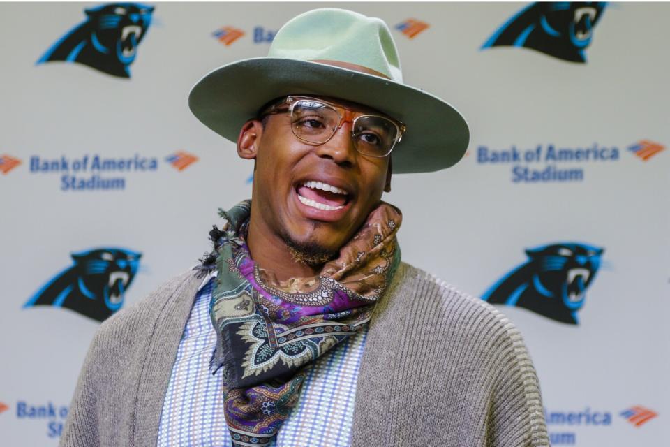 Carolina quarterback Cam Newton wears an unusual outfit, featuring a hat and colorful scarf, during a news conference