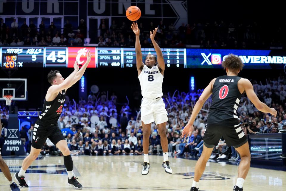 Xavier Musketeers guard Quincy Olivari (8) rises for a 3-point basket in the second half of the 91st Crosstown Shootout basketball game between the Cincinnati Bearcats and the Xavier Musketeers, Saturday, Dec. 9, 2023, at Cintas Center in Cincinnati. The Xavier Musketeers won, 84-79.