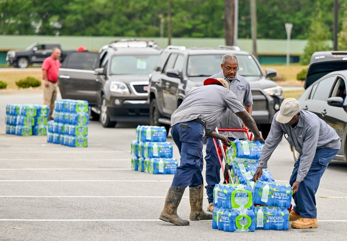 Volunteers and city workers hand out cases of water at the Baldwin County Government Center in Milledgeville Thursday afternoon. The city gave out 864 cases of drinkable water Wednesday night.