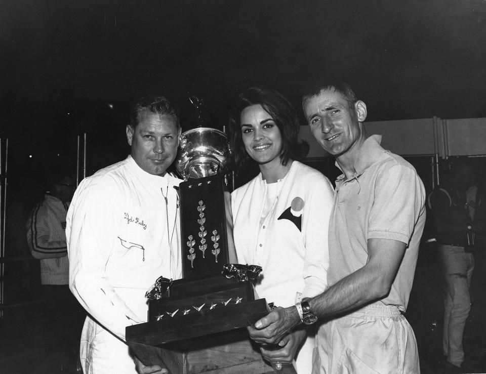 DAYTONA BEACH, FL - FEBRUARY 28, 1965:  Race winners Lloyd Ruby and Ken Miles are joined in victory lane by the reigning Miss Universe, Corinna Tsopei of Greece, following their win in the Daytona Continental at Daytona International Speedway. (Photo by ISC Images & Archives via Getty Images)