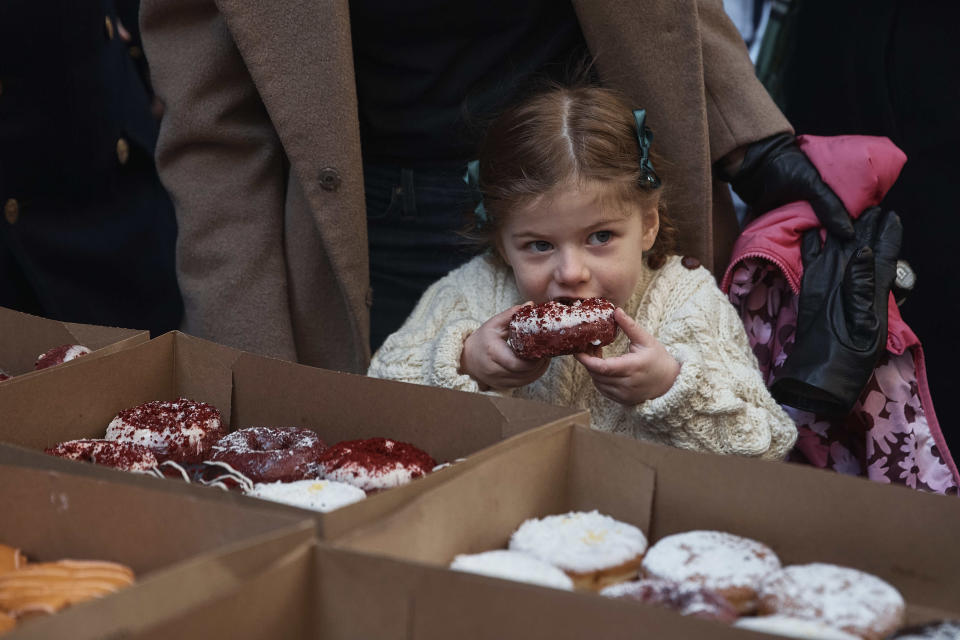A child eats a donut during the St. Patrick's Day Parade on Saturday, March 16, 2024, in New York. (AP Photo/Andres Kudacki)