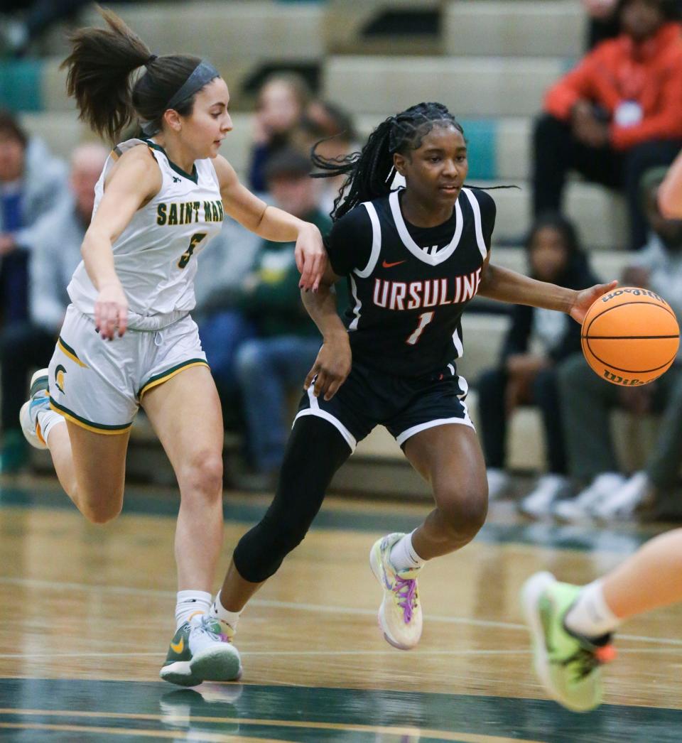 Saint Mark's Leah DePaul (left) trails as Ursuline's Taylor Brown takes the ball on the offensive in the first half of Ursuline's 72-48 win at Saint Mark's, Thursday, Jan. 18, 2024.