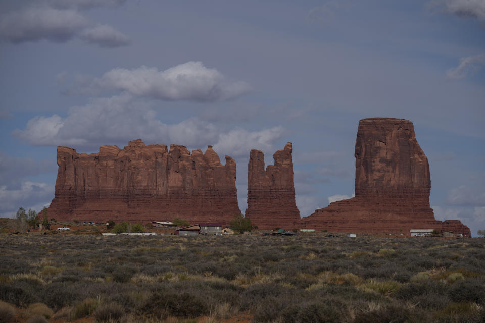 In this April 19, 2020, photo, homes and other structures are seen in Monument Valley, Ariz., on the Navajo reservation. Even before the pandemic, people living in rural communities and on reservations were among the toughest groups to count in the 2020 census. (AP Photo/Carolyn Kaster)