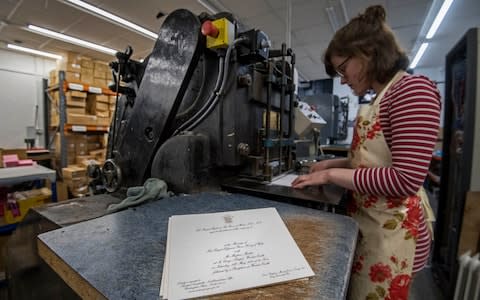 Lottie Small use the die stamping press at the workshop of Barnard and Westwood - Credit: Victoria Jones /PA