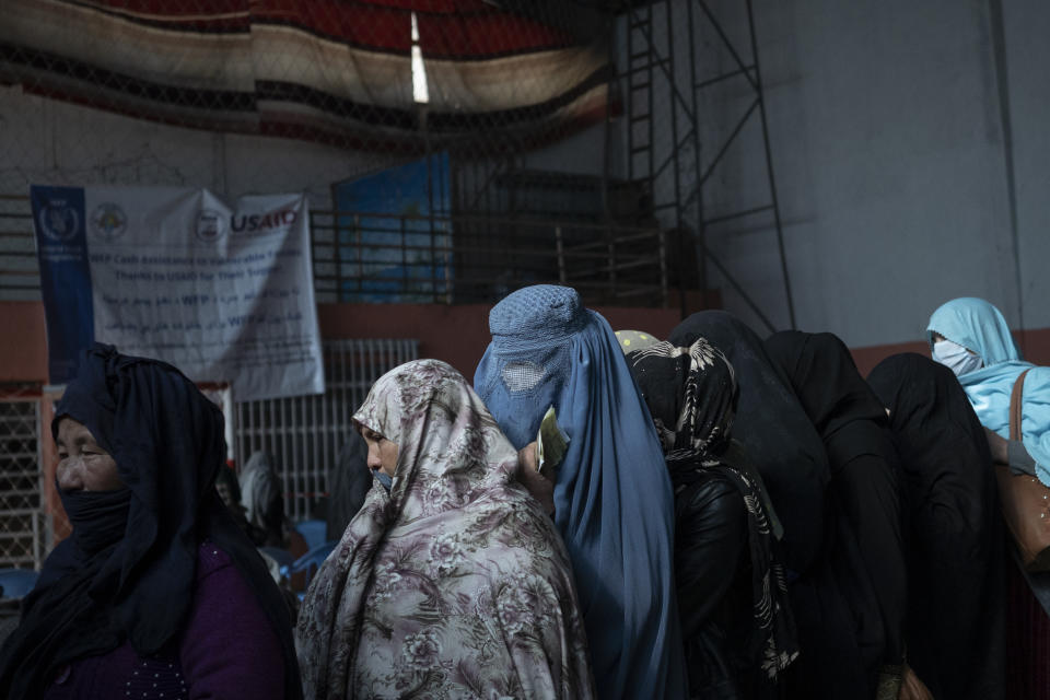 Women wait in a line to receive cash at a money distribution organized by the World Food Program (WFP) in Kabul, Afghanistan, Wednesday, Nov. 3, 2021. Afghanistan's economy is fast approaching the brink and is faced with harrowing predictions of growing poverty and hunger. (AP Photo/Bram Janssen)