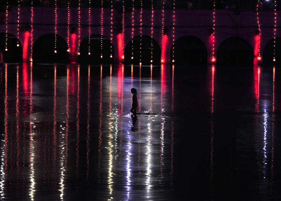 A devotee crosses Saryu river after after lighting up earthen lamps on a day before the arrival of Prime Minister Narendra Modi for Ground breaking ceremony of Ram Temple ,during the Covid 19 pandemic, in Ayodhya, India on August 4, 2020. (Photo by Ritesh Shukla/NurPhoto via Getty Images)