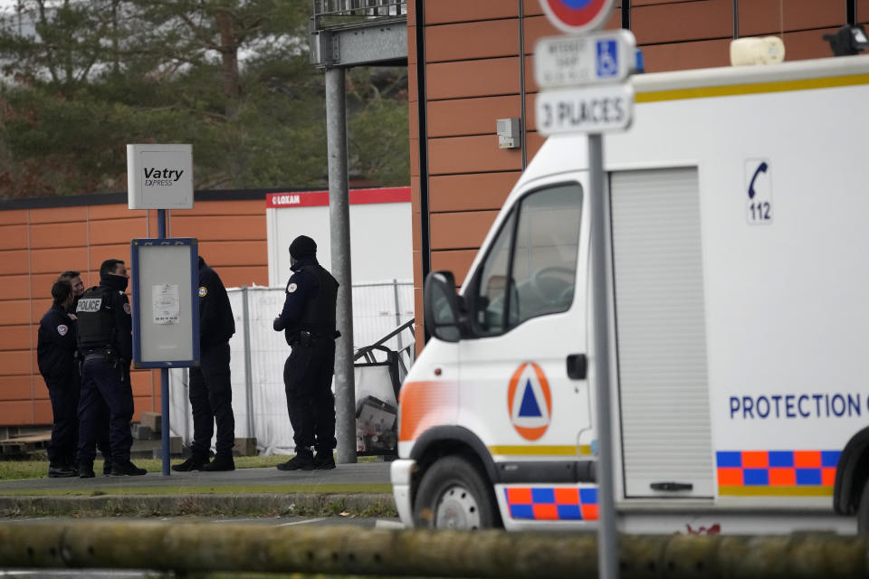 Police officers stand near a rescue vehicle outside the Vatry airport, eastern France, Saturday, Dec. 23, 2023 in Vatry, eastern France. About 300 Indian citizens heading to Central America were sequestered in a French airport for a third day Saturday because of an investigation into suspected human trafficking, authorities said. The 15 crew members of the Legend Airlines charter flight en route from United Arab Emirates to Nicaragua were questioned and released, according to a lawyer for the small Romania-based airline. (AP Photo/Christophe Ena)