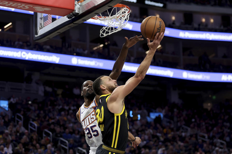 Golden State Warriors guard Stephen Curry (30) shoots against Phoenix Suns forward Kevin Durant (35) during the second half of an NBA basketball game in San Francisco, Saturday, Feb. 10, 2024. (AP Photo/Jed Jacobsohn)