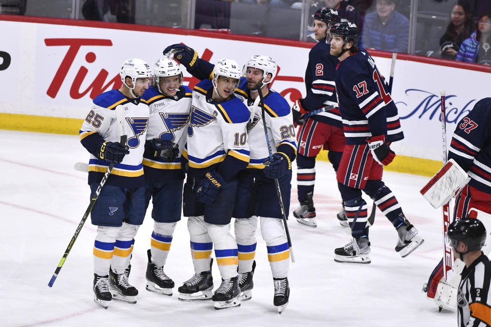 St. Louis Blues' Robert Thomas (18) celebrates his goal against the Winnipeg Jets with Jordan Kyrou (25), Brayden Schenn (10) and Brandon Saad (20) during the third period of an NHL hockey game Tuesday, Oct. 24. 2023, in Winnipeg, Manitoba. (Fred Greenslade/The Canadian Press via AP)