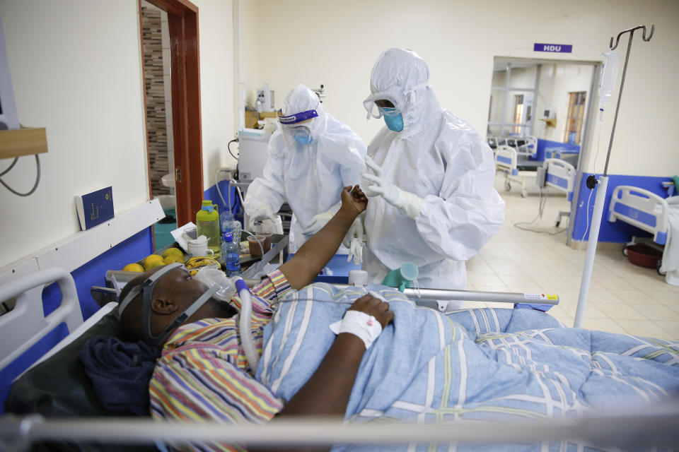 FILE — In this Thursday June 17, 2021 file photo medical staff wearing protective equipment attend to patients affected by COVID-19, on the Intensive Care Unit (ICU) of the Machakos County Level-5 hospital in Machakos, Kenya. Driven by the delta variant, a new wave of COVID-19 is sweeping across the African continent where new cases, hospital admissions, and deaths are increasing. (AP Photo/Brian Inganga/File)