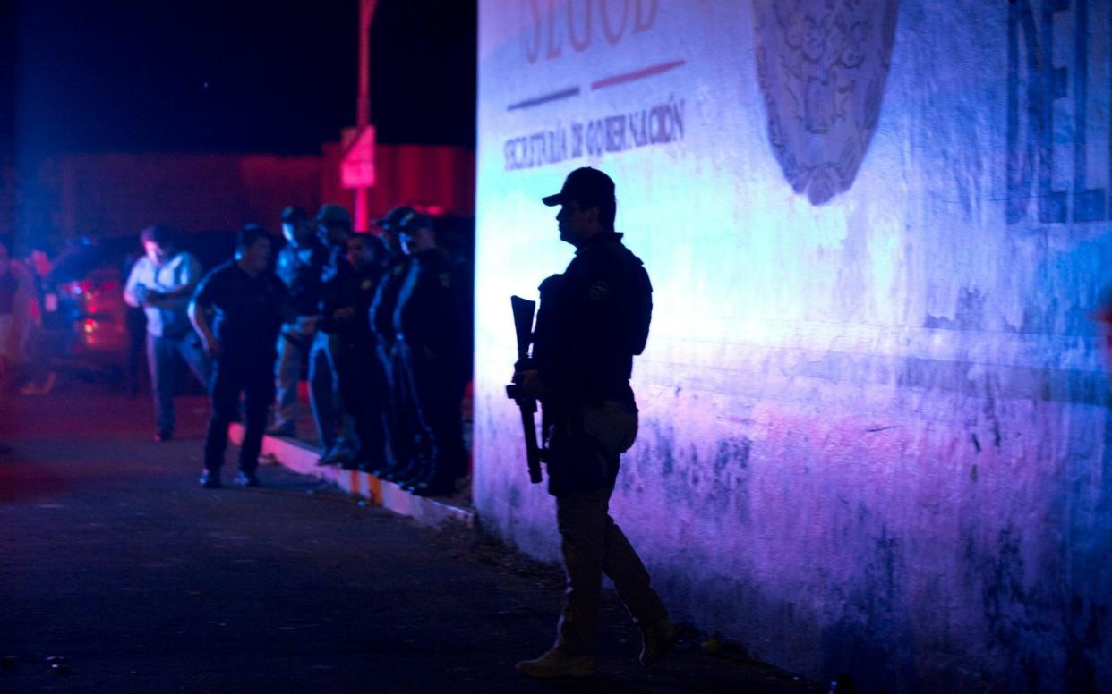 A police offer stands guard outside the detention centre from where 1,300 migrants escaped on Thursday night - AP