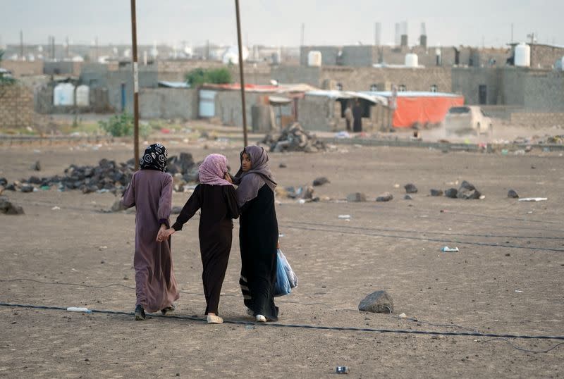 Girls walk at a makeshift camp for internally displaced people (IDPs) in the oil-producing Marib province