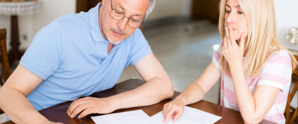 Mature couple looking at and discussing personal finances