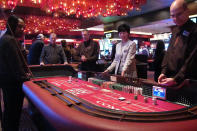 In this Feb. 22, 2019 photo, players gather around a table of craps at the Golden Nugget casino in Atlantic City N.J. Commercial casinos in 25 U.S. states won $43.6 billion from gamblers in 2019, an increase of nearly 4% from the previous year, according to a report issued late Wednesday, June 3, 2020, by The American Gaming Association, the casino industry’s national trade group. (AP Photo/Wayne Parry)