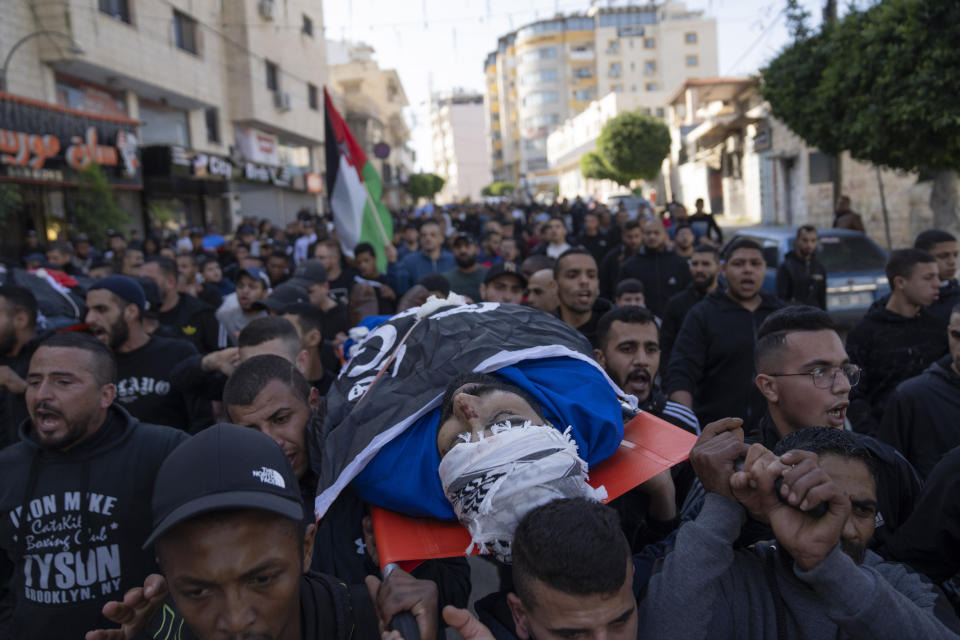 Mourners carry the body of Ahmad Bad, during his funeral in the West Bank refugee camp of Tulkarem, Friday, Jan. 19, 2024. The Israeli army withdrew early morning from the Tulkarem refugee camp after a 45 hours wide military operation in the refugee camp, the Israeli army said. Eight Palestinians were killed by the Israeli army during the Israeli army operation in the refugee camp, the Palestinian health ministry said. (AP Photo/Nasser Nasser)