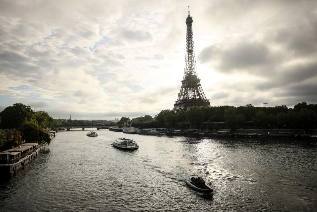 FILE - Barges cruise on the Seine River near the Eiffel Tower during a rehearsal for the 2024 Paris Olympic opening ceremony, June. 17, 2024, in Paris. (AP Photo/Thomas Padilla, File)