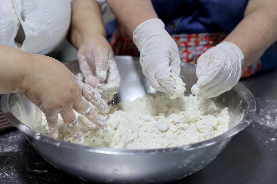 Cheryl Day, owner Back in the Day Bakery, and Savannah Morning News Editor Amy Condon work in pats of butter, by breaking them down and smooshing them with their fingers.