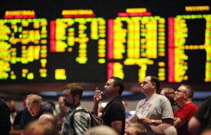 Bettors wait in line to place a wager on the NCAA college basketball tournament in the sports book at The Mirage in Las Vegas Thursday, March 20, 2014. (AP Photo/Las Vegas Review-Journal, John Locher)