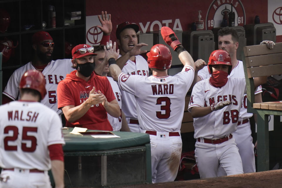 Los Angeles Angels' Taylor Ward, center, is greeted by teammates after he scored on a single hit by Justin Upton during the eighth inning of a baseball game against the Houston Astros, Sunday, Sept. 6, 2020, in Anaheim, Calif. (AP Photo/Jae C. Hong)