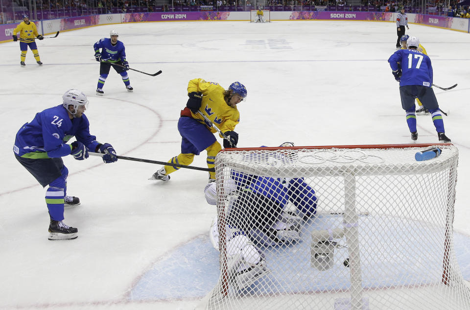 Sweden forward Carl Hagelin, center, shoots and scores against Slovenia goaltender Robert Kristan in the third period of a men's ice hockey game at the 2014 Winter Olympics, Wednesday, Feb. 19, 2014, in Sochi, Russia. (AP Photo/Mark Humphrey)