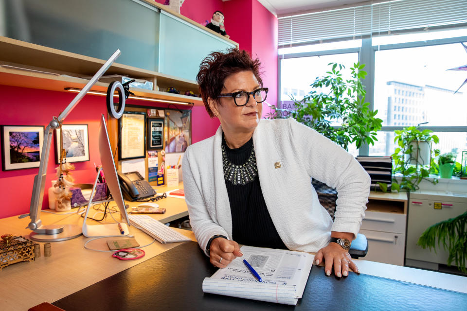 Melissa Grant at her desk in an office decorated in bright fuchsia and duck egg blue.